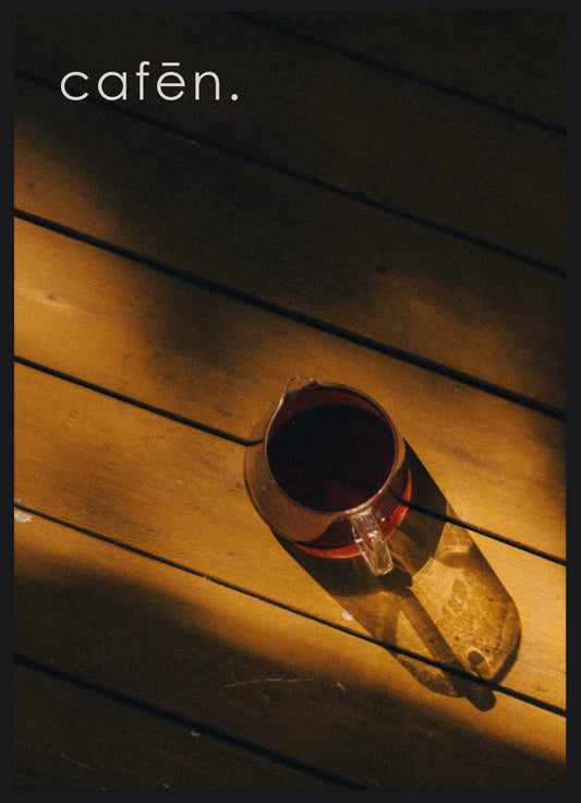 Cup of coffee on a wooden surface with 'cafen' branding.