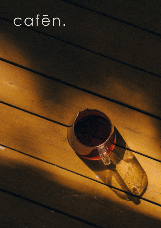 Coffee cup on a wooden surface with 'cafén.' text above